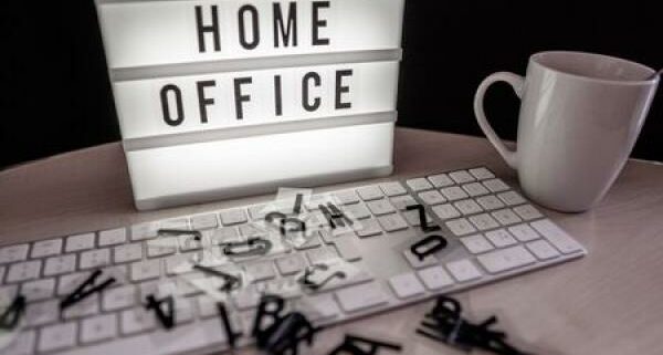 A sign behind a keyboard that reads "Home Office"